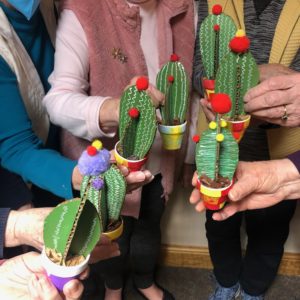 Picture of residents with cactus sculptures they created