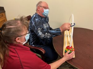 A patient exercises manual dexterity with a physical therapy assistant